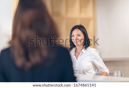 Smile female receptionist at counter in hotel