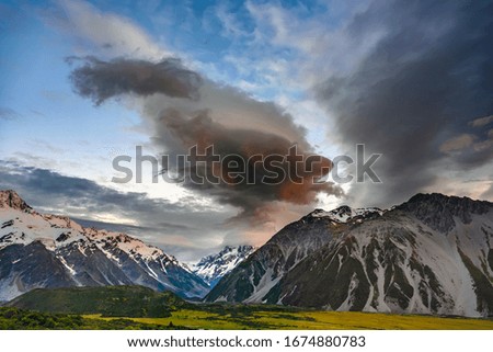 High mountain views on the top of the mountain are white snow in the morning with dramatic sky and clouds with green grass in in Mount Cook National Park in south island of New Zealand