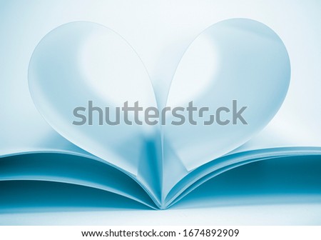 Two blank magazine pages that becomes one heart shape. Clean front view photo of magazine on white background, as concept for valentines day, love story etc.