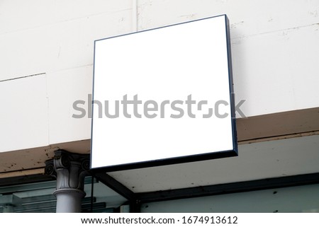 Blank square white store signboard empty shop lightbox on mall wall 