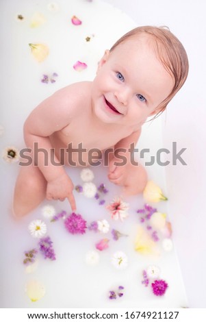 Child on the milk bath with flowers