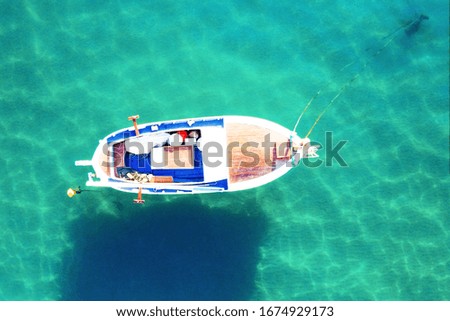 Little boat on clear turquoise water, sea or ocean, top view. Beautiful stunning picture. Outdoors, sunny day.