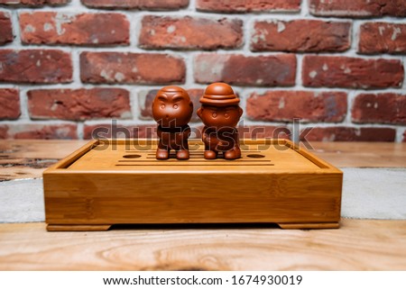 Chinese tea ceremony. Dishes for tea with the famous chinese puerh tea on wood table with stone background.