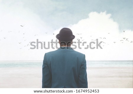 man in blue suite and bowler observing seagulls over the sea, surreal abstract concept Royalty-Free Stock Photo #1674952453