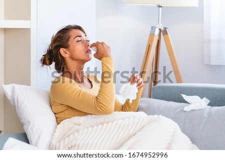 Woman is having flu and she is using nasal spray to help herself. Woman using nasal spray. Nasal spray to help a cold. Sick with a rhinitis woman dripping nose. Woman applies nasal spray