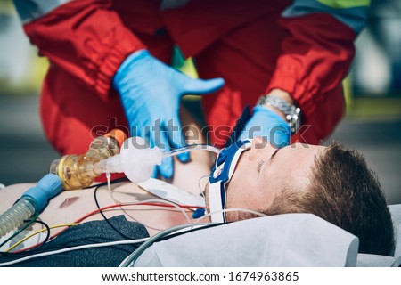 Paramedic of emergency medical service helping man after cardiopulmonary resuscitation. Themes help, hope a health care. Royalty-Free Stock Photo #1674963865
