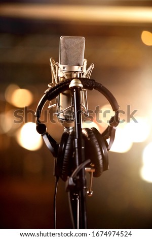 Headphones hanging on a stand for Condenser Microphone in a Music Recording Studio
