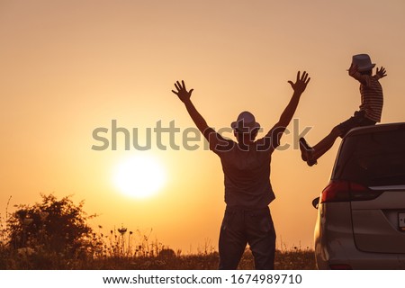 Father and son playing in the park at the sunset time. People having fun on the field. Concept of friendly family and of summer vacation. Royalty-Free Stock Photo #1674989710