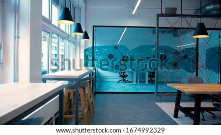 Office with a transparent meeting room. tables along the window.