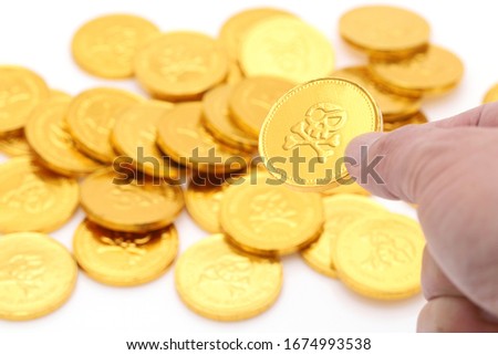 Pirate gold coins with a skull. Holding a gold coin in hand