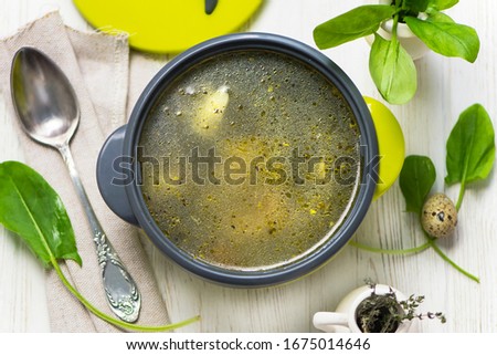sorrel spinach soup with vegetables on chicken stock in a pan