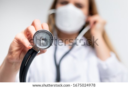 Female doctor with a stethoscope and virus protective mask medical care concept