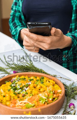 Woman take photo picture of food with phone. Smartphone chickpea vegetables buddha bowl photography. Blogging, social media concept. Vegan, vegetarian healthy diet. Kitchen or summer cafe
