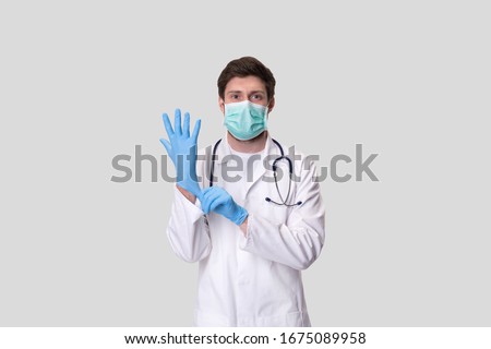 Doctor Puts on Gloves and Wearing Medical Mask. Medical Concept Corona Virus Royalty-Free Stock Photo #1675089958