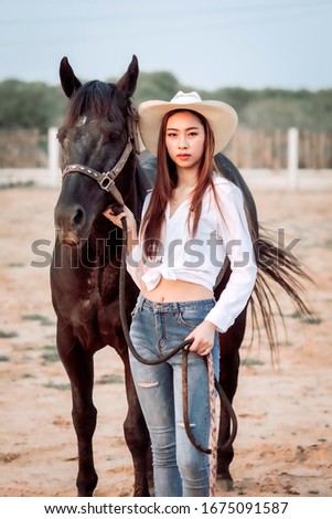 Beautiful Asia girl taking care of her horse with love and caring.