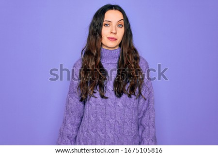 Young beautiful woman wearing casual turtleneck sweater standing over purple background looking sleepy and tired, exhausted for fatigue and hangover, lazy eyes in the morning.