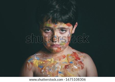 child with face painting on black background