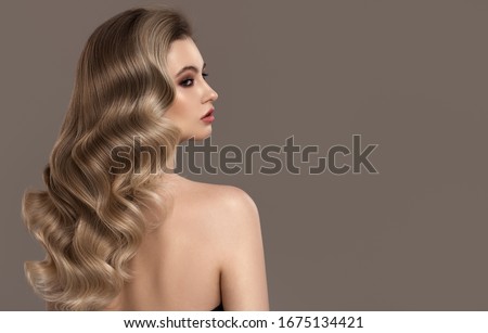 Portrait of young blonde woman. Long beautiful wavy hair.