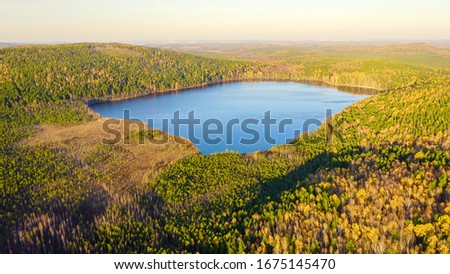Yekaterinburg, Russia. Lake Peschanoye (Sandy) is rectangular in shape surrounded by forest in the fall. Sunset time, Aerial View  