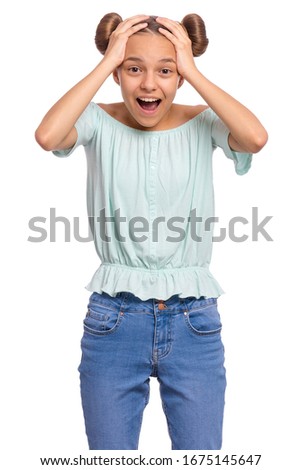 Portrait of surprised teen girl, isolated on white background. Funny child looking at camera in amazement, touching head with hands. Beautiful caucasian teenager, opening eyes and mouth with shock.