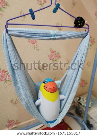 a penguin toy in a cradle