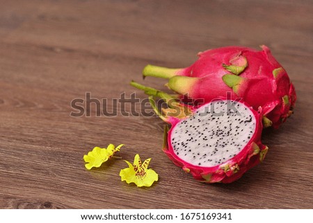 Close up view of exotic dragon fruit sliced isolated on a wooden background. Fresh vegetarians vitamin delicious food. Beautiful picture of summer vacation fruits