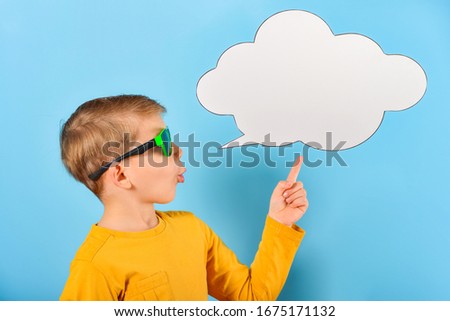 The boy shows on a blank poster for the inscription in the form of a cloud on a blue background.