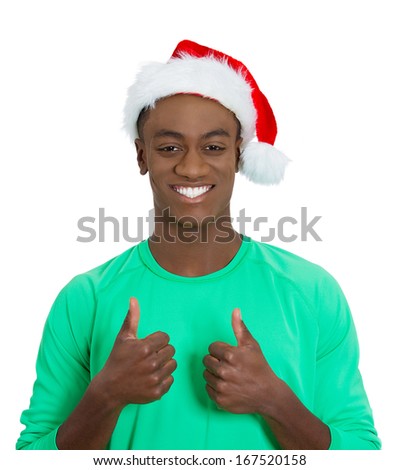 Closeup portrait of young handsome happy, smiling excited man in red santa hat giving two thumbs up sign with fingers, isolated on white background. Positive emotion facial expressions and symbols