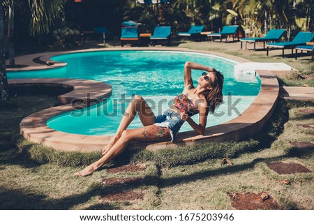 Emotional portrait of Fashion stylish portrait of pretty young hipster blonde woman posing in the swimming pool. hat, swimsuit, outdoor fashion portrait 
,going crazy,elegant black hat cool 