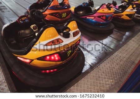 Empty bumper cars with glowing lights at the amusement park. Fairground with attractions. Colorful dodgems. Royalty-Free Stock Photo #1675232410