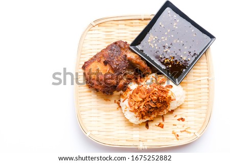 A picture of "pulut ayam thai" or thai sticky rice with fried chicken on rattan tray and copy space.