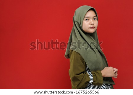 Portrait of Beautiful Young Muslim woman posing on red background, Medium Close-up.