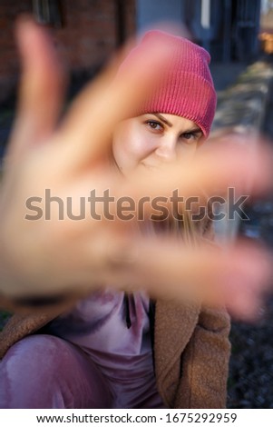 stylish girl model in a brown coat, pink suit and pink hat smiles beautifully. The trends of modern fashion. Fashionable image. Bright emotions