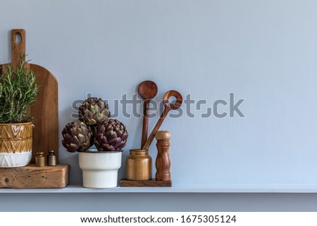 Modern composition on the kitchen interior with vegetables, herbs, cutting board, kitchen accessories and copy space on the shelf.