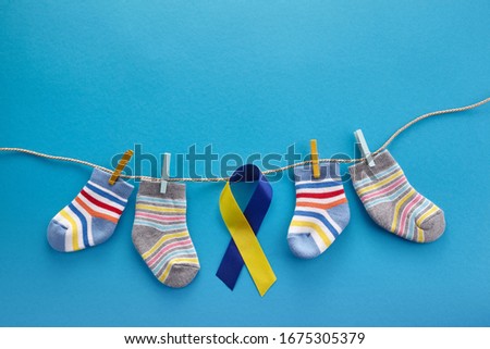 World Down syndrome day background. Down syndrome awareness concept. Socks and ribbon on blue background Royalty-Free Stock Photo #1675305379
