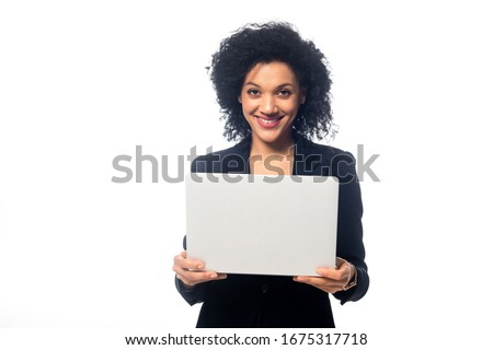 Front view of african american businesswoman holding laptop, smiling and looking at camera isolated on white