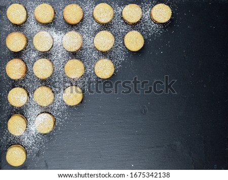 Traditional serbian homemade vanilla cookies, vanilice, modern geometric food design, on the black background, minimalist food, powdered with sugar, top view