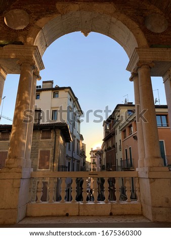 View of old town of Vicenza from an arch of Basilica Palladiana during sunset.