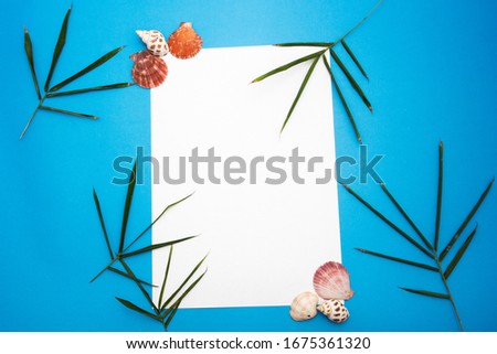 Blank paper with frames adorned and Bamboo leaves, shell, and blue paper background. Concept to put text to advertise products. Banners, marketing.
