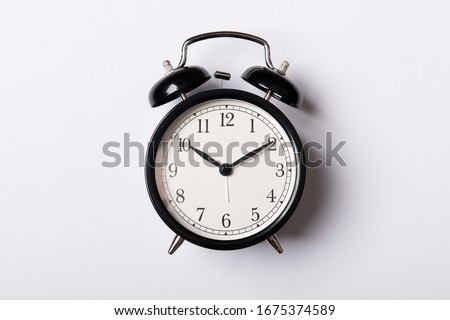 Black vintage alarm clock on white background. Time concept