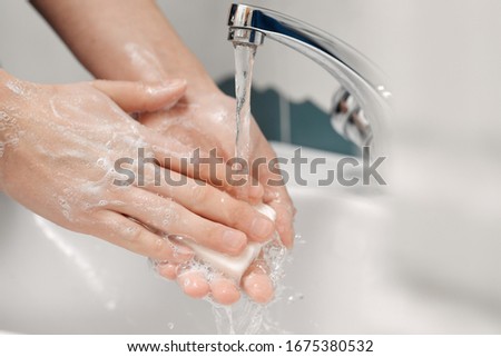 Washing hands for disinfection. Soap bubbles in water. Corona virus