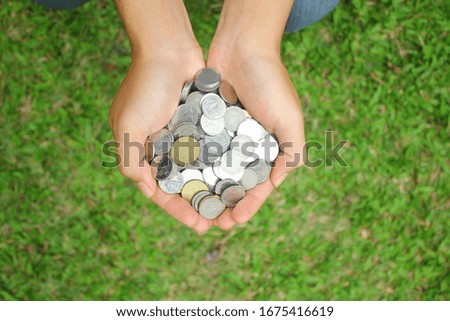 hand is holding many coins Free Photo in green background