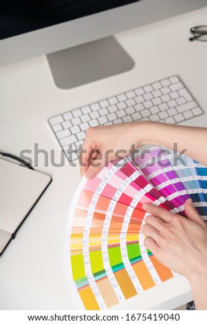 Graphic designer at work chooses colors for printing