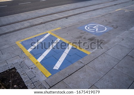 Parking signs painted on the concrete, indicating a spot of disabled persons