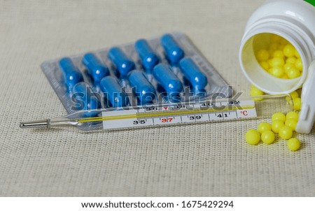 
Various medicines in tablets and capsules. Mercury thermometer. Medicine concept. Pharmaceutical blister pack.