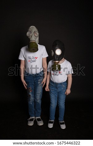Two girls posing in respirators on black background