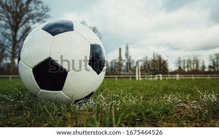 Typical soccer ball on the free kick marking line, outdoors on the stadium field. Traditional football ball on the green grass turf before goal. Spring sports leisure and healthy activity.