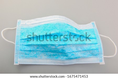 Typical three-layer protective surgical mask. The edge with double stitches is designed to cover the nose, and a metal wire is concealed within so the mask can be fitted securely to the nasal bridge.