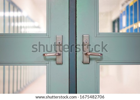 School closed due to weather, holiday, Professional Activity PA day and public health risk. School closure concept. Double door handles,  blurred hallway locker background.  Royalty-Free Stock Photo #1675482706