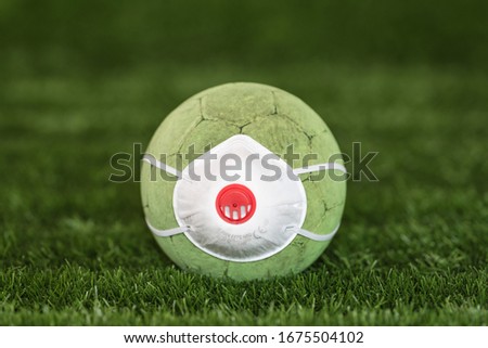 The soccer ball with face mask as a symbol coronavirus